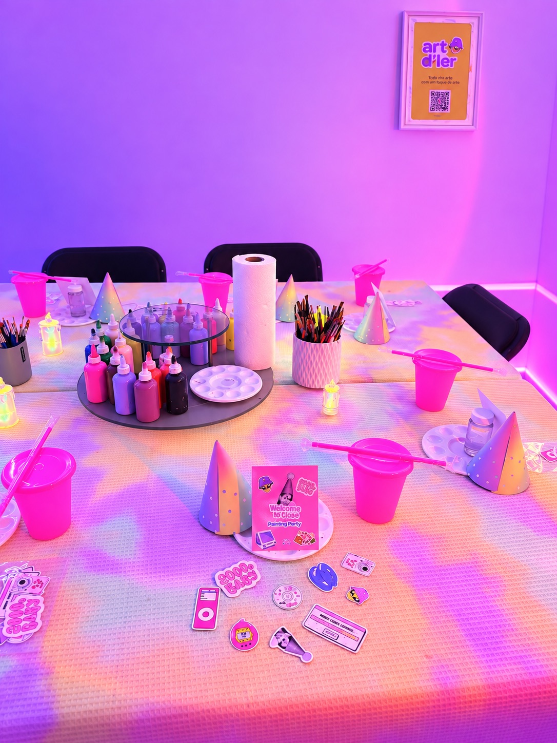 Mesa preparada con pinturas, pinceles y decoración para un evento privado